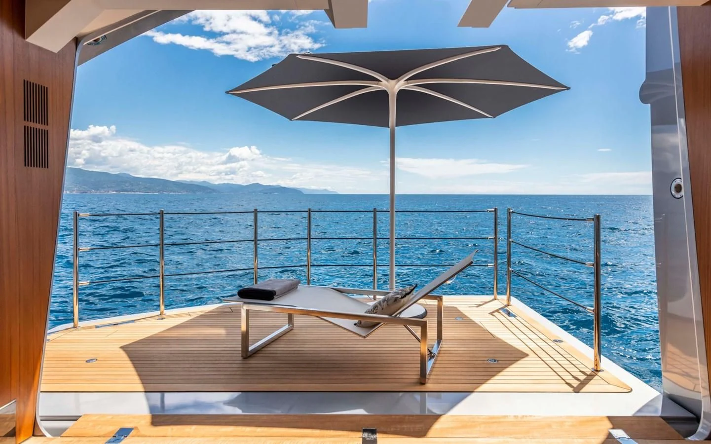 a lounge chair on a deck overlooking the ocean aboard TOUCH ME Yacht for Sale
