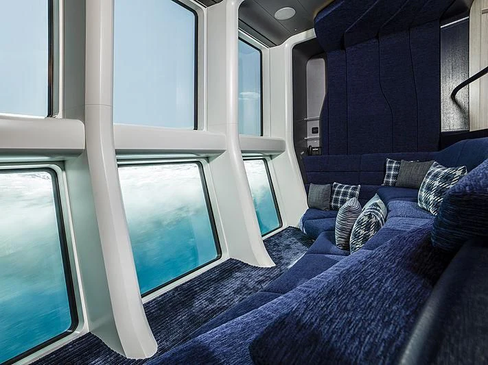 a blue couch with a window aboard M'BRACE Yacht for Sale