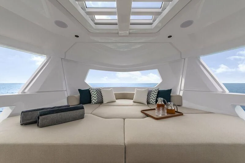 a white room with a couch and a table with a glass of beer aboard INFYNITO 90/01 Yacht for Sale