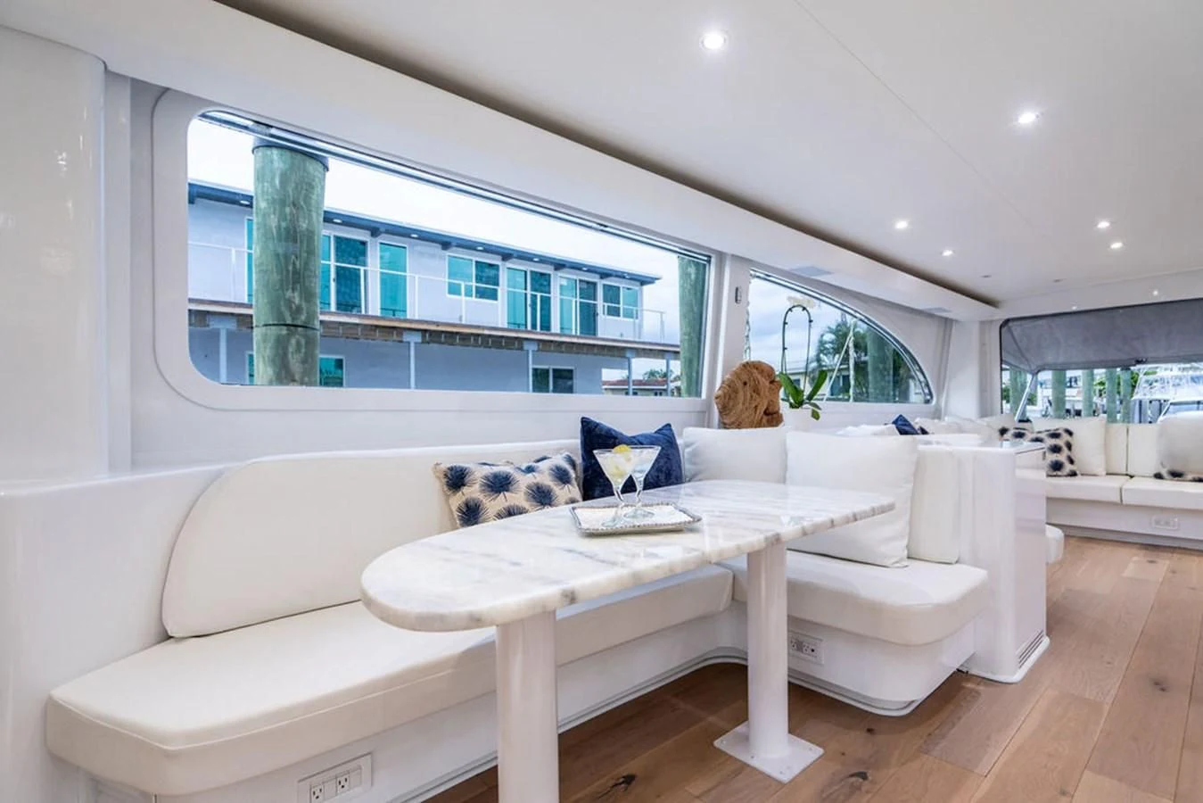 a white couch and a table in a room with a large window aboard COURTNEY ANNE Yacht for Sale