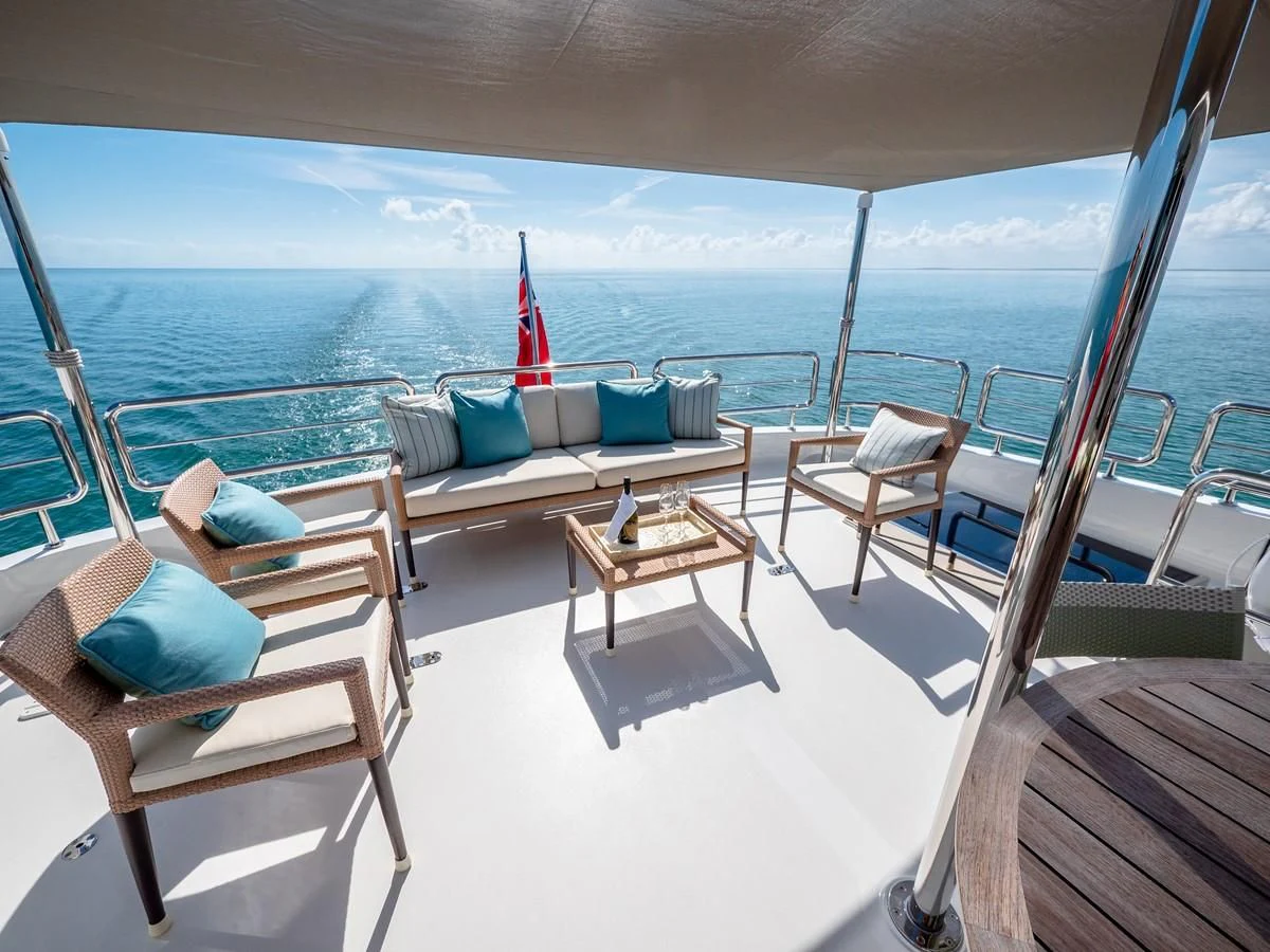 a deck with chairs and a table on it aboard SEA N SEA Yacht for Sale