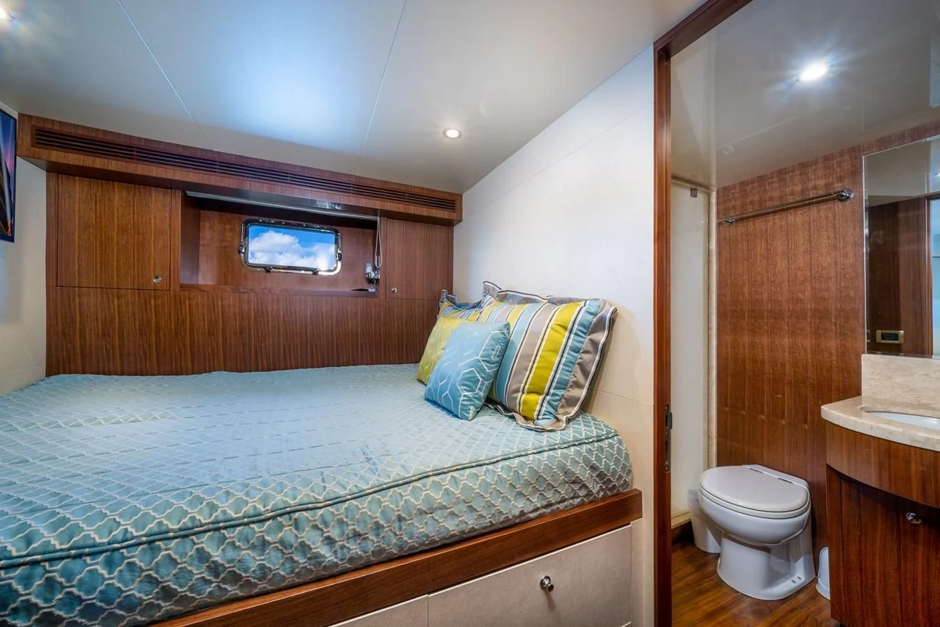 a bedroom with a bed and a wood cabinet aboard SEA N SEA Yacht for Sale