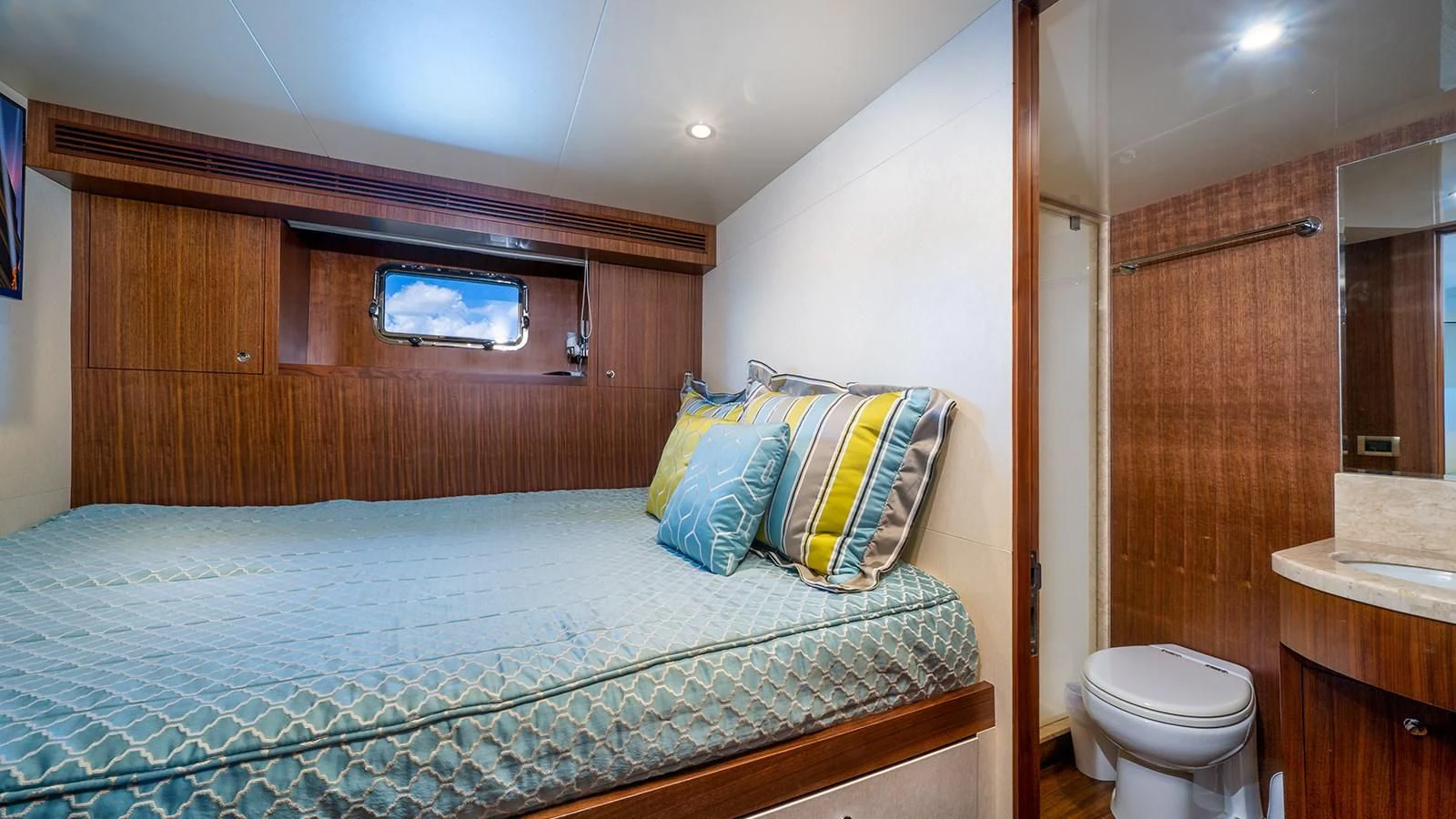 a bedroom with a bed and a wood cabinet aboard SEA N SEA Yacht for Sale
