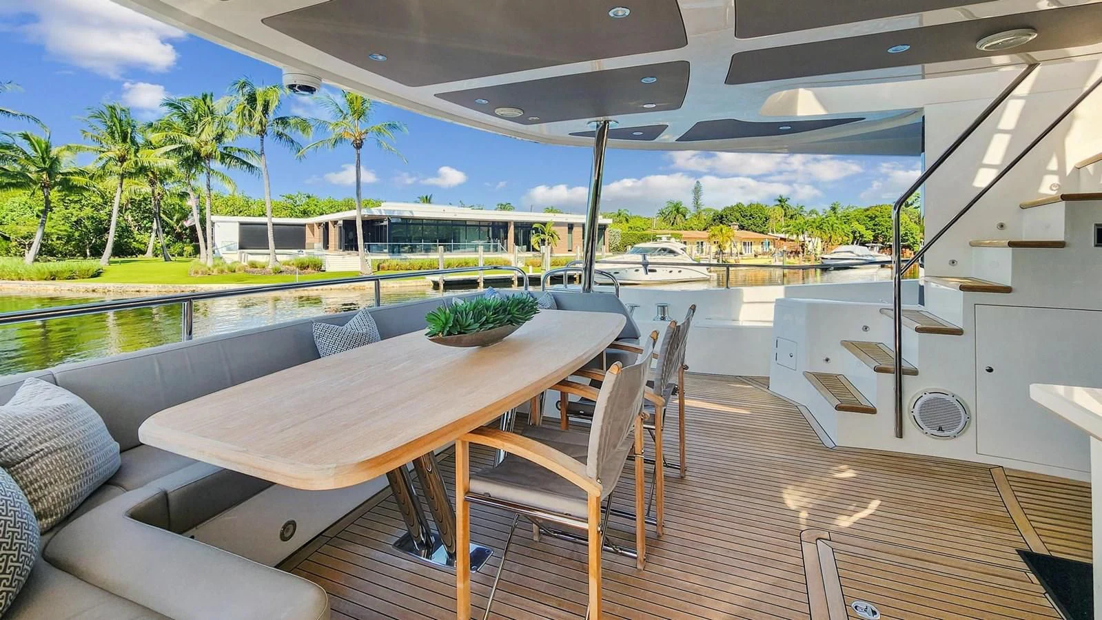 a deck with a table and chairs aboard F5 Yacht for Sale
