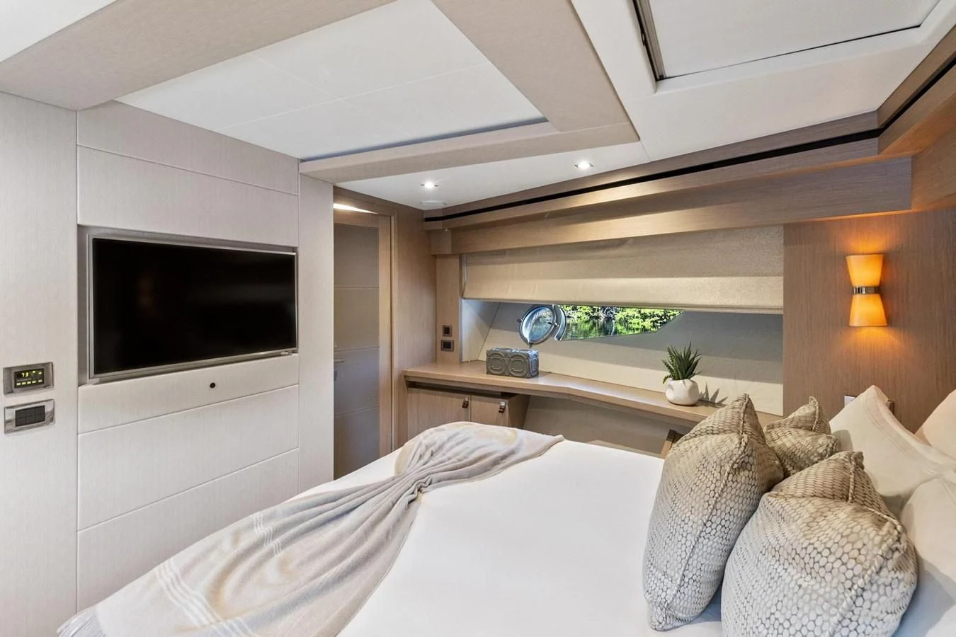 a bed with a television on the wall aboard F5 Yacht for Sale