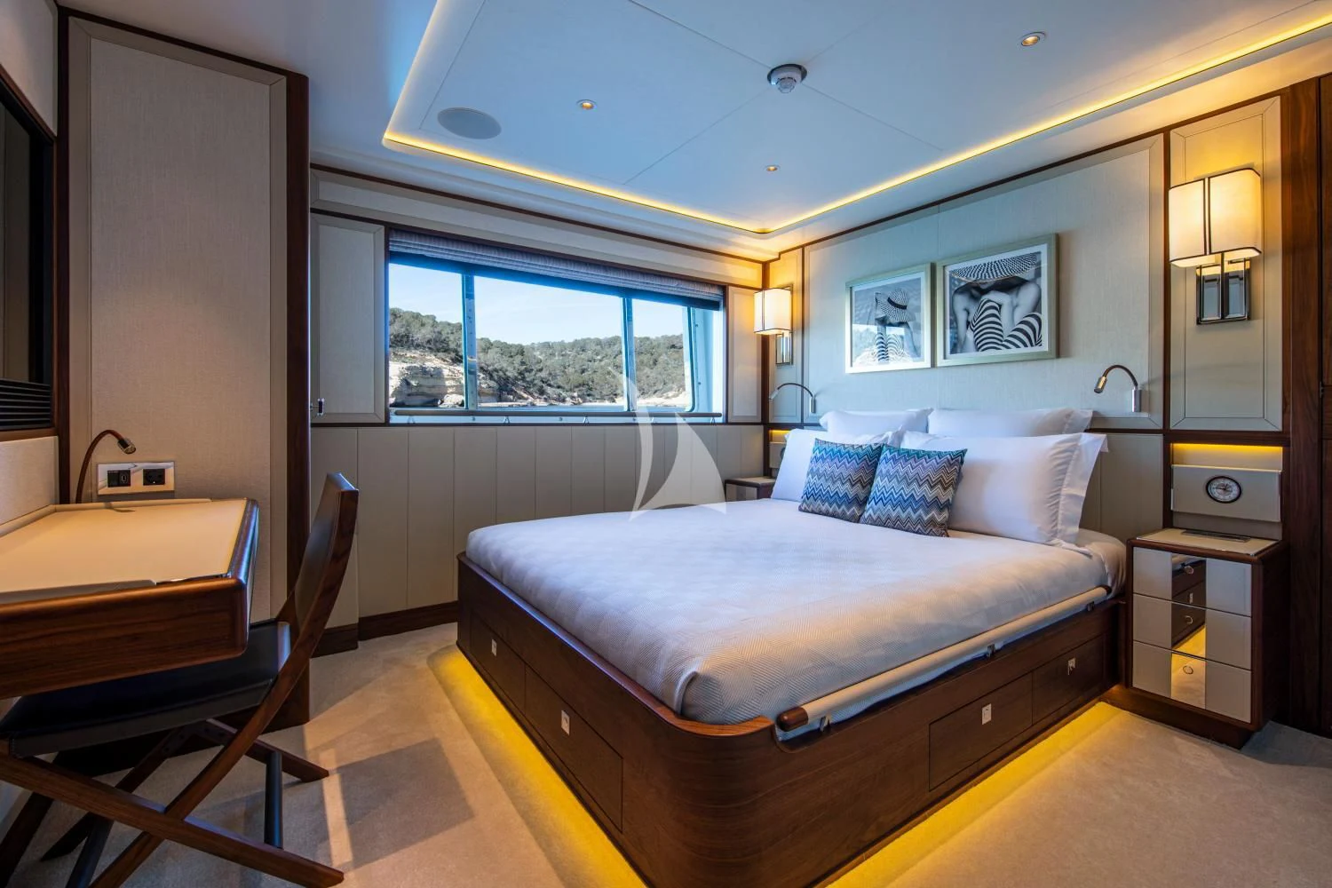 a bedroom with a bed and a desk aboard DELTA ONE Yacht for Charter