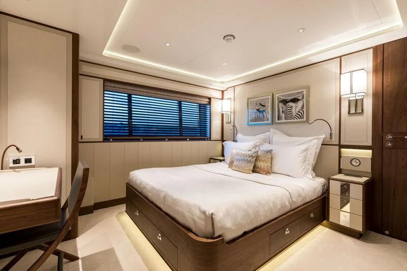 a bedroom with a bed and a desk aboard DELTA ONE Yacht for Charter