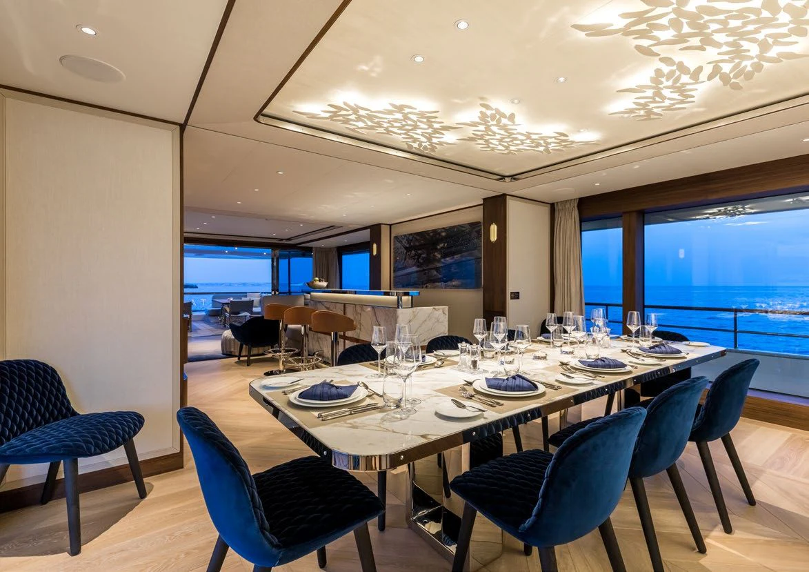 a large dining room with blue chairs aboard DELTA ONE Yacht for Charter