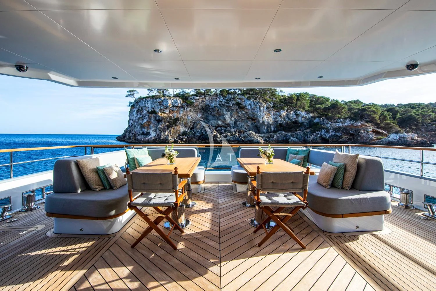 a room with a couch and a table and chairs on a deck aboard DELTA ONE Yacht for Charter