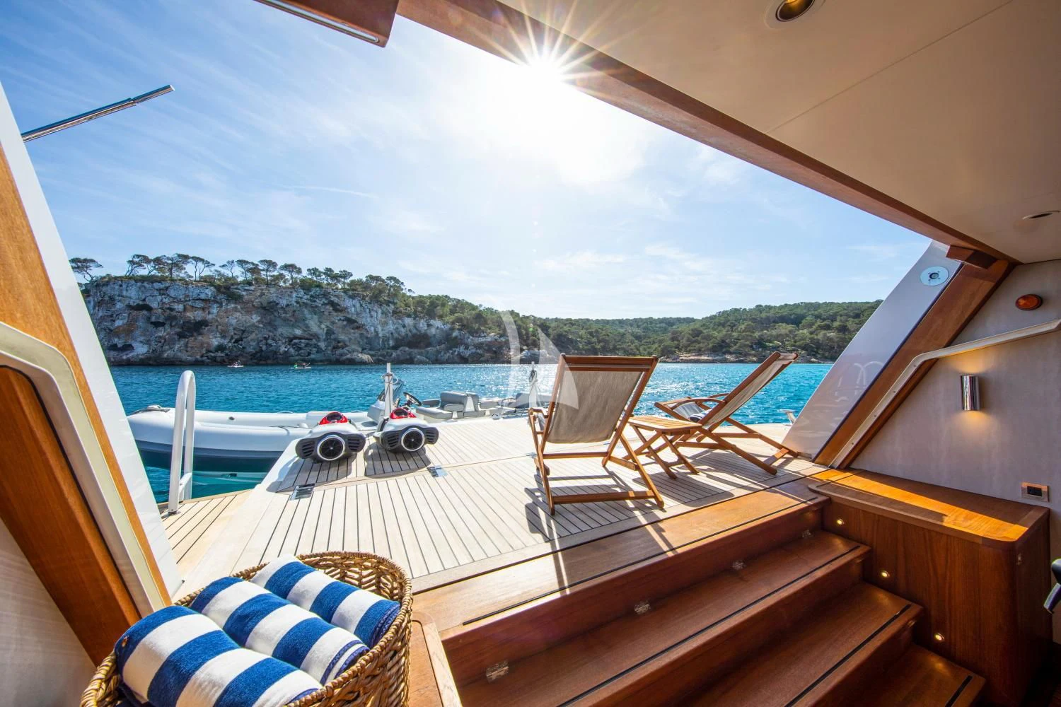 a deck with a view of the ocean and the mountains aboard DELTA ONE Yacht for Charter