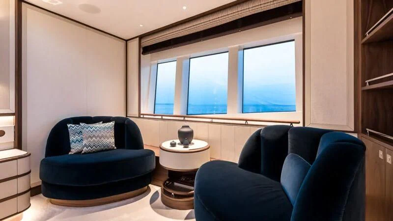 a living room with a blue couch and a window aboard DELTA ONE Yacht for Charter
