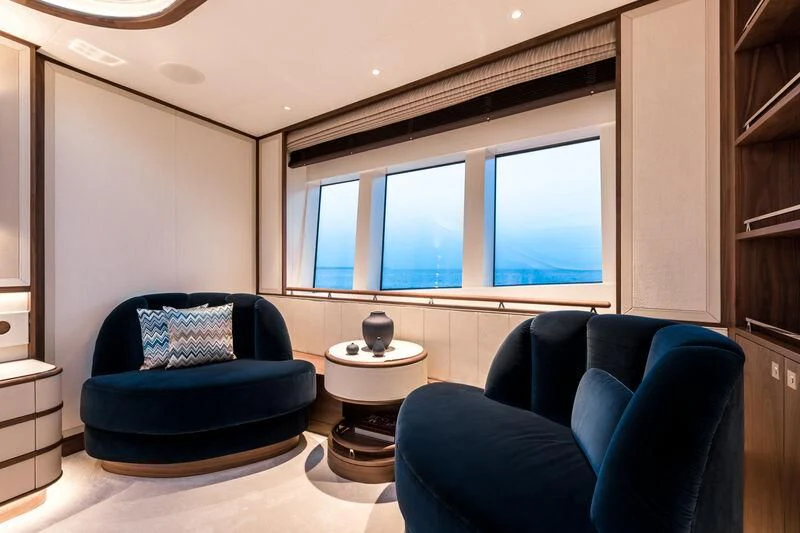 a living room with blue chairs aboard DELTA ONE Yacht for Charter