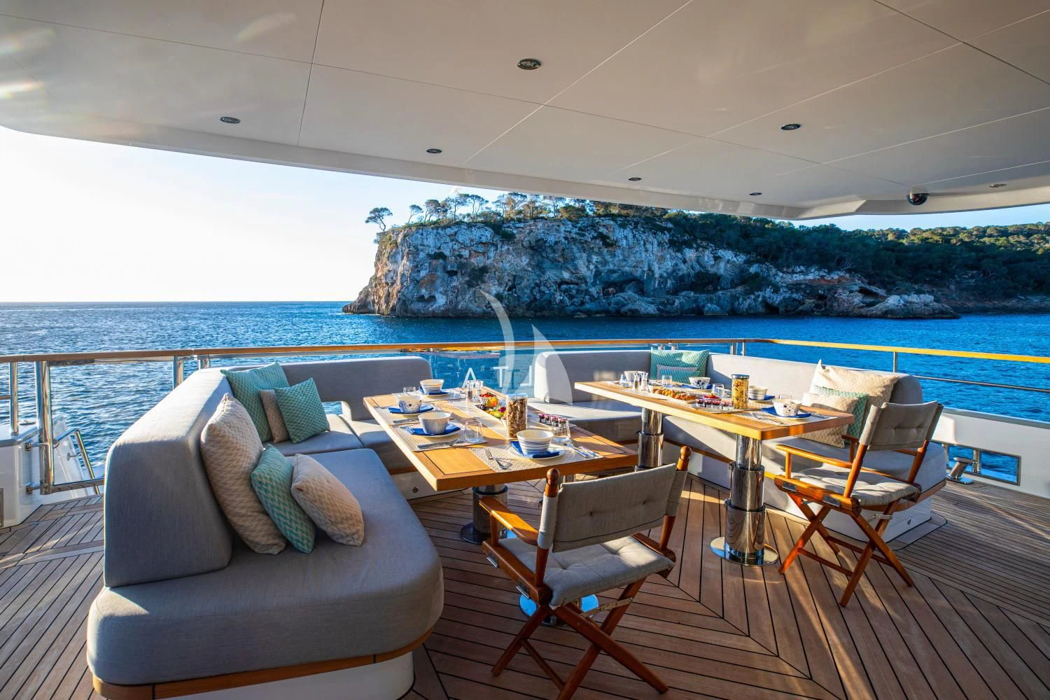a room with a couch and a table and chairs and a large rock on the wall aboard DELTA ONE Yacht for Charter