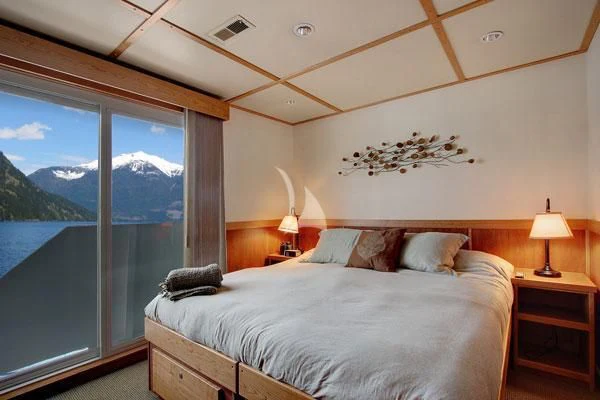 a bed with a large window aboard SAFARI QUEST Yacht for Sale