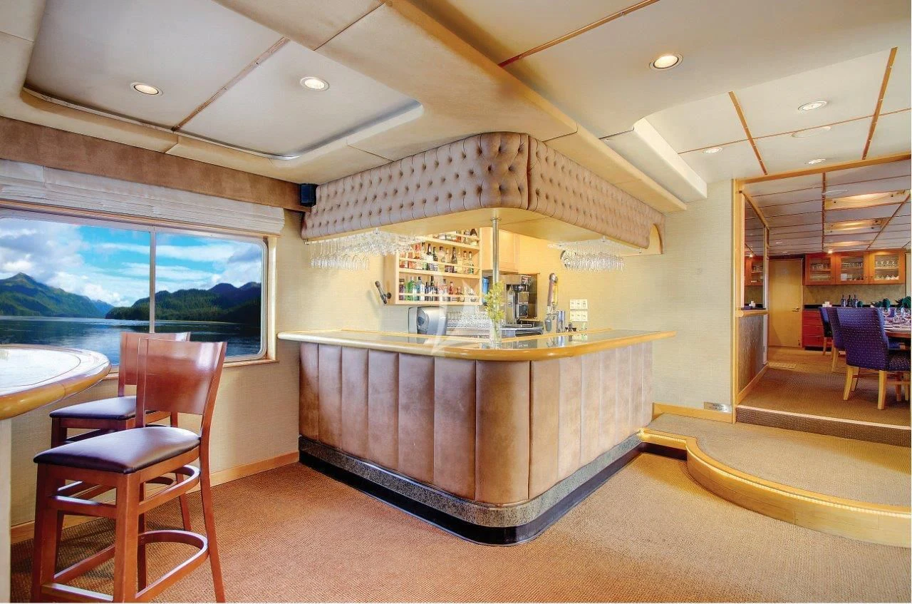 a kitchen with a bar and stools aboard SAFARI QUEST Yacht for Sale