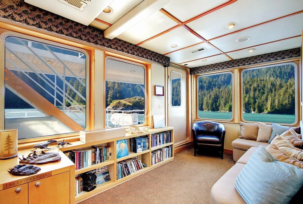 a room with a couch and a bookcase aboard SAFARI QUEST Yacht for Sale