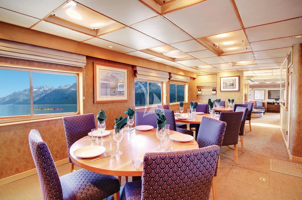 a large dining room with a table and chairs aboard SAFARI QUEST Yacht for Sale