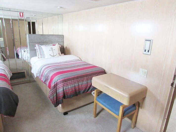 a room with a bed and a chair aboard GOOD NEWS Yacht for Sale