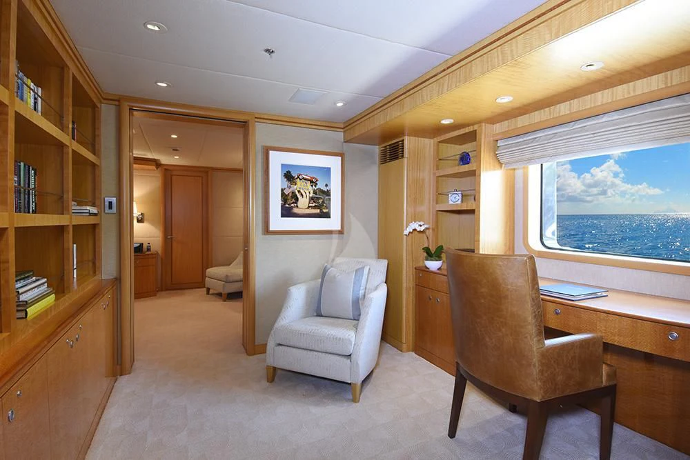 a living room with a chair and a bookcase aboard HELIOS 2 Yacht for Sale
