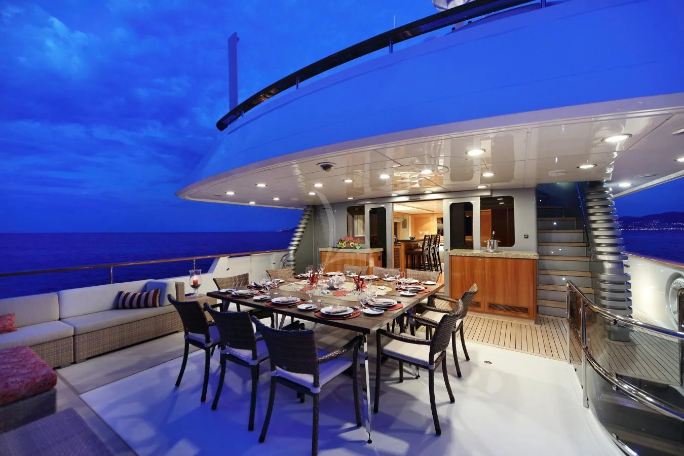 a large dining table with chairs and a large patio with a view of the ocean aboard HELIOS 2 Yacht for Sale