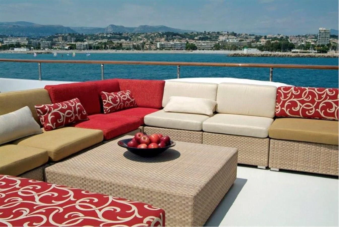 a couch and a table with fruit on it by a body of water aboard HELIOS 2 Yacht for Sale