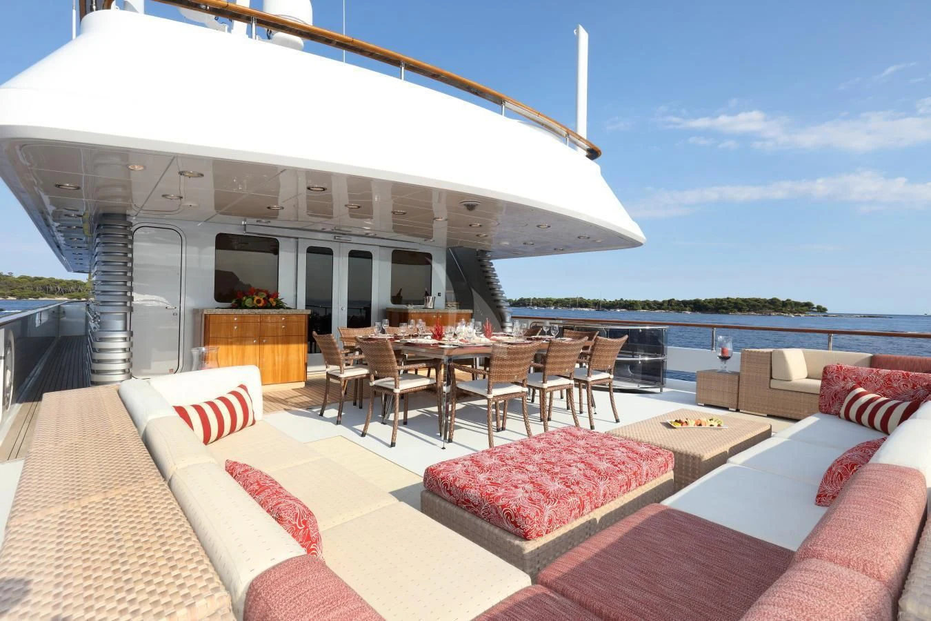 a lounge area with a patio and a building with a pool and blue sky aboard HELIOS 2 Yacht for Sale