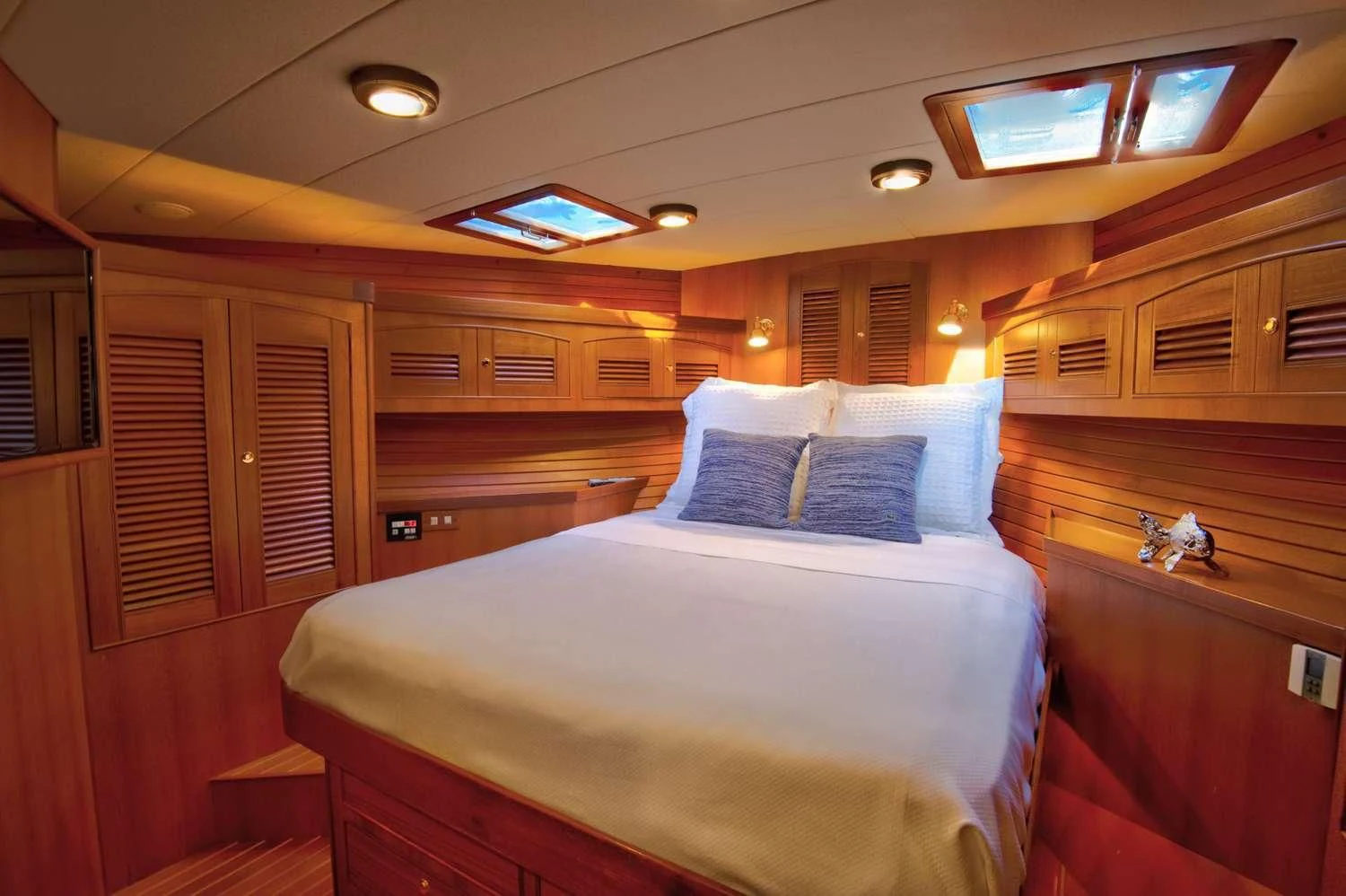 a room with a bed and a wood cabinet aboard HALCYON SEAS Yacht for Sale