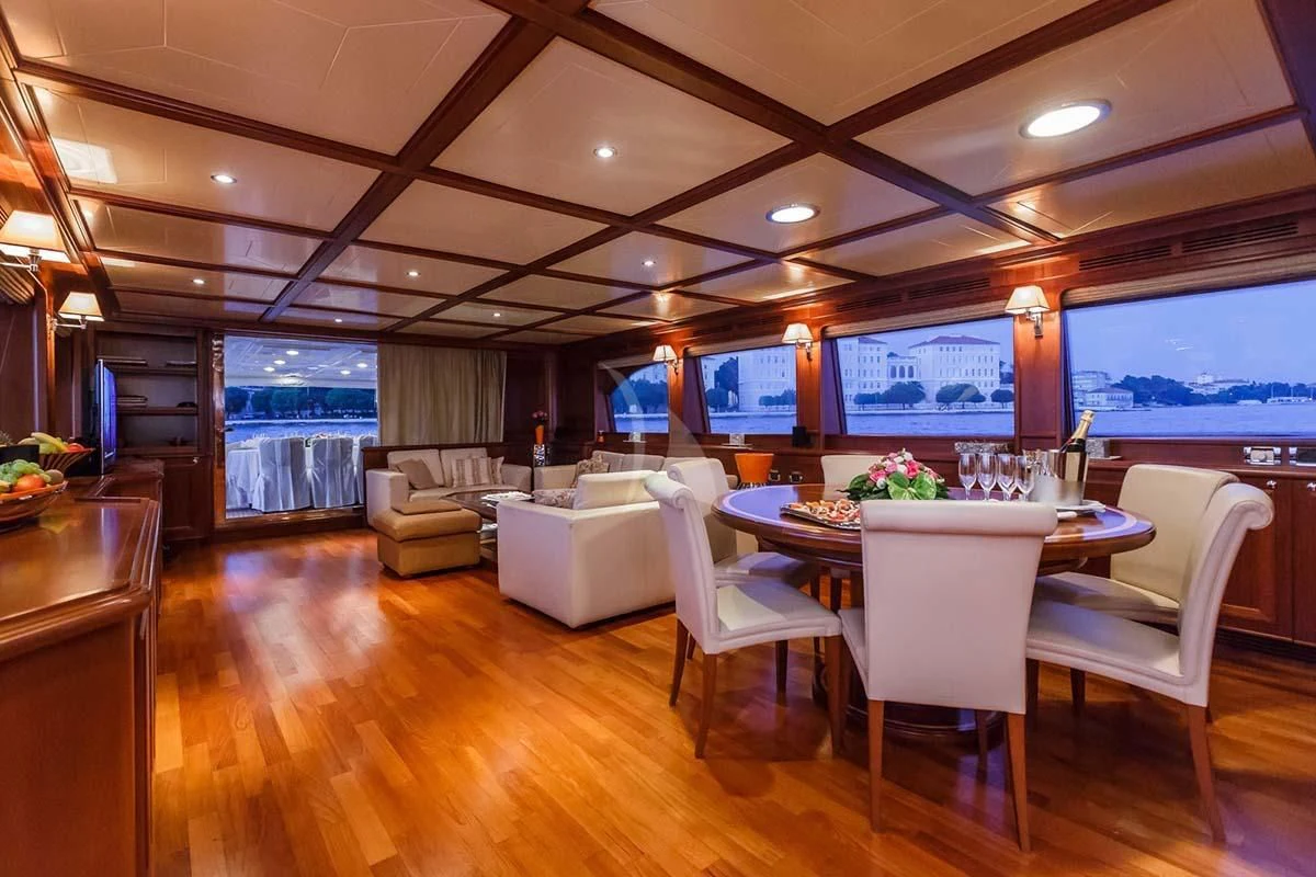 a room with a table chairs and a television aboard KLOBUK Yacht for Charter
