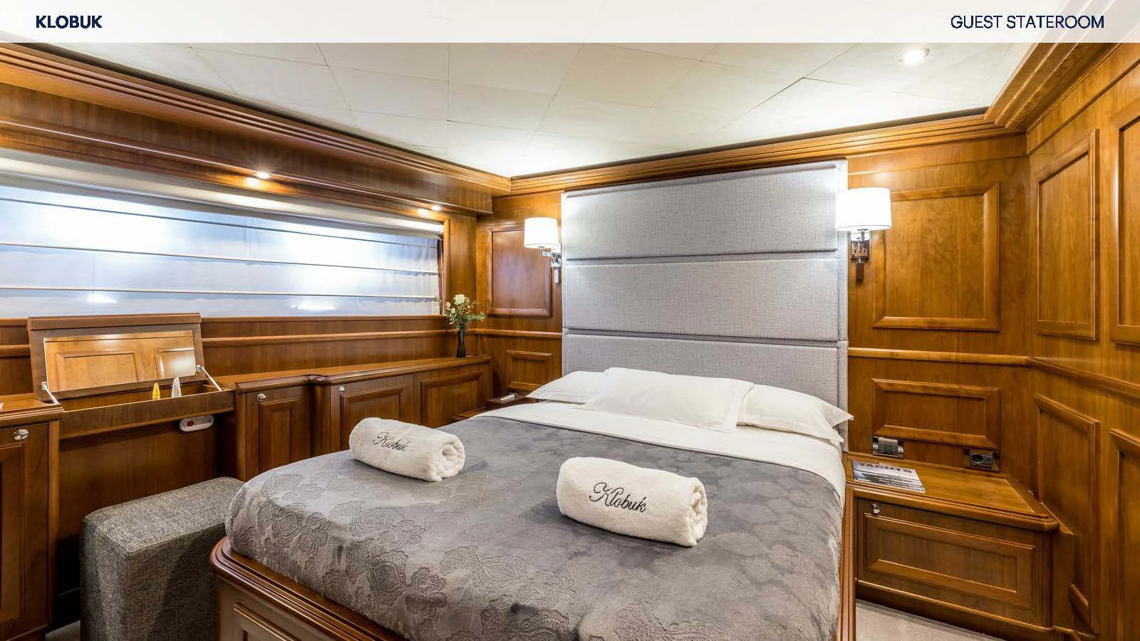 a bedroom with a bed and a dresser aboard KLOBUK Yacht for Charter