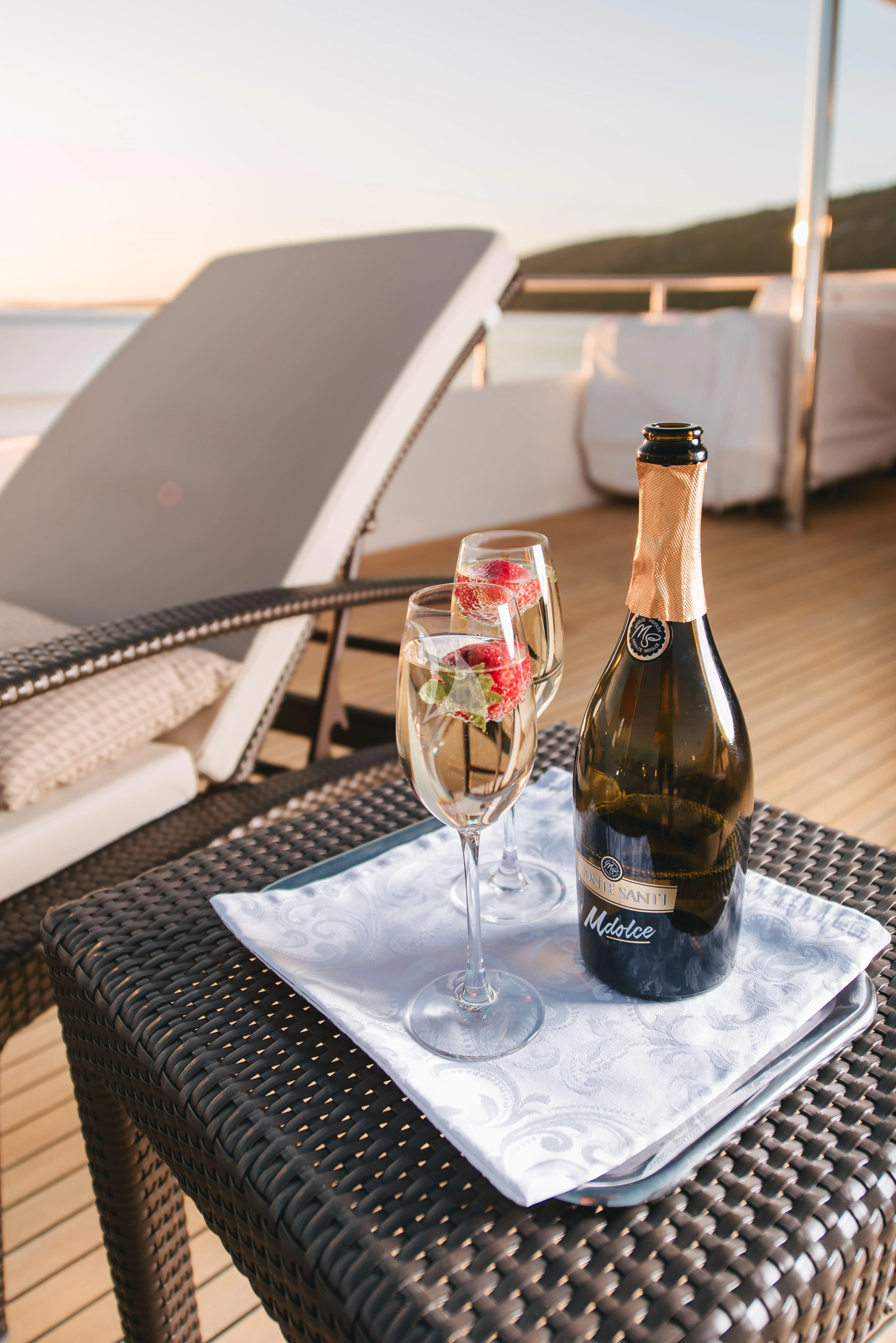 a bottle of wine and a glass of wine on a table aboard KLOBUK Yacht for Charter