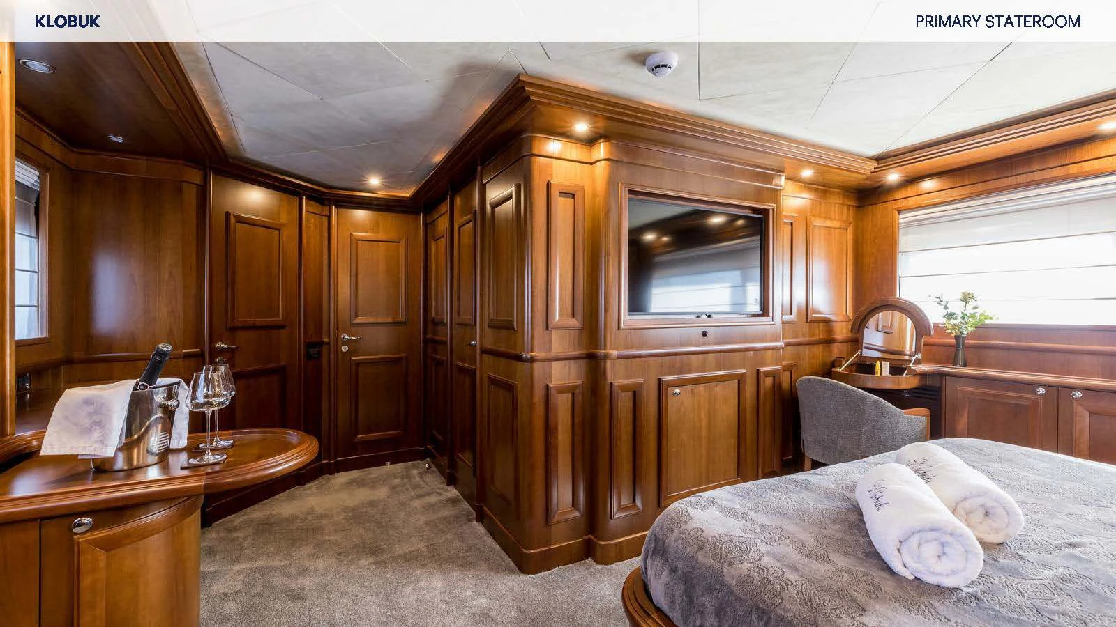 a bedroom with a bed and a glass door aboard KLOBUK Yacht for Charter