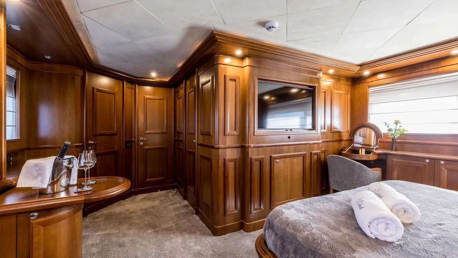 a bedroom with a bed and a glass door aboard KLOBUK Yacht for Charter
