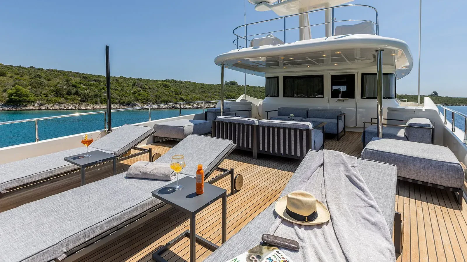 a deck with a table and chairs and a pool aboard KLOBUK Yacht for Charter