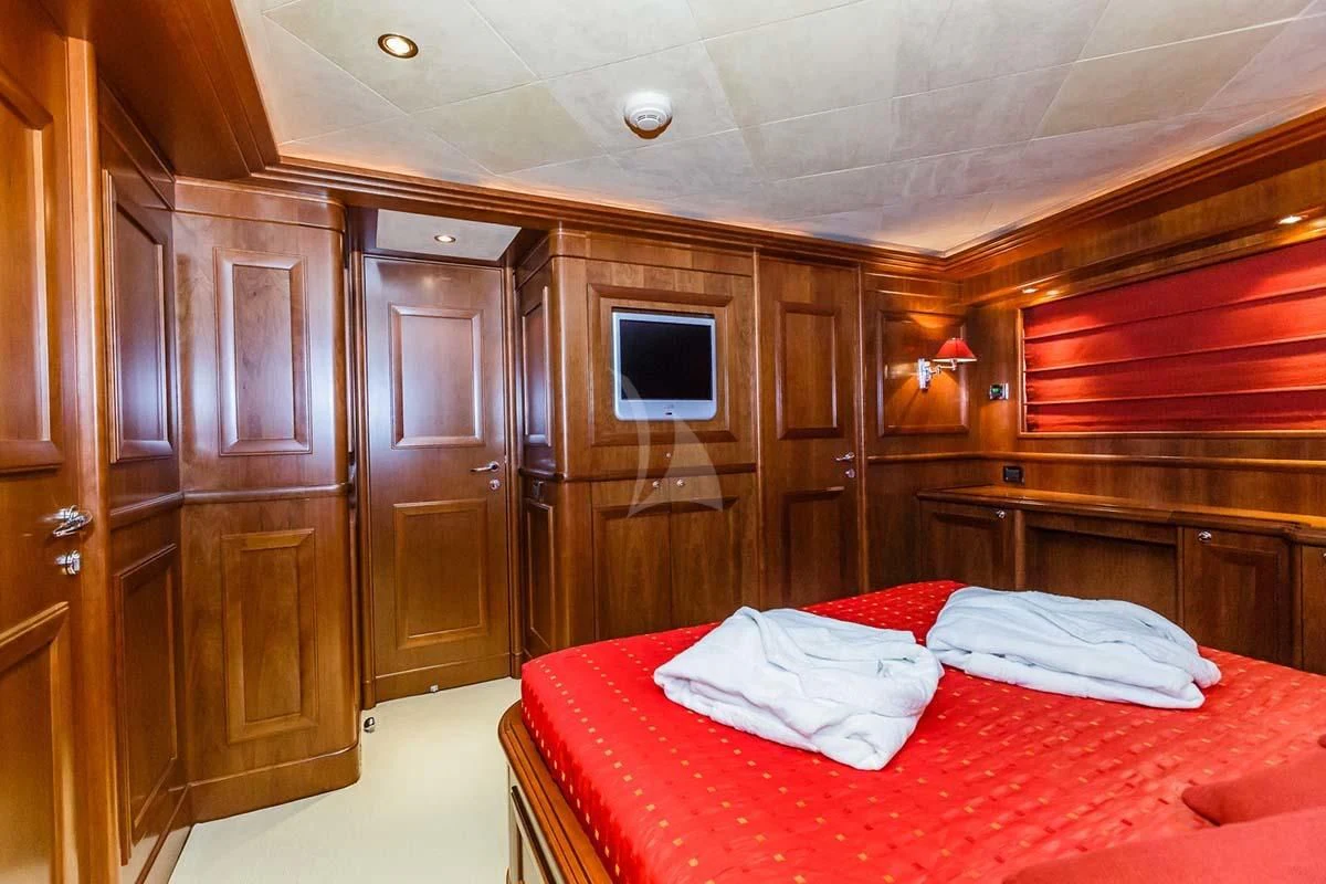 a bedroom with a bed and a television aboard KLOBUK Yacht for Charter
