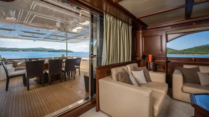 a room with a couch and a table and a large window aboard KLOBUK Yacht for Charter