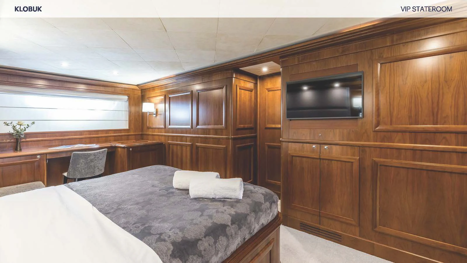 a room with a bed and a television aboard KLOBUK Yacht for Charter