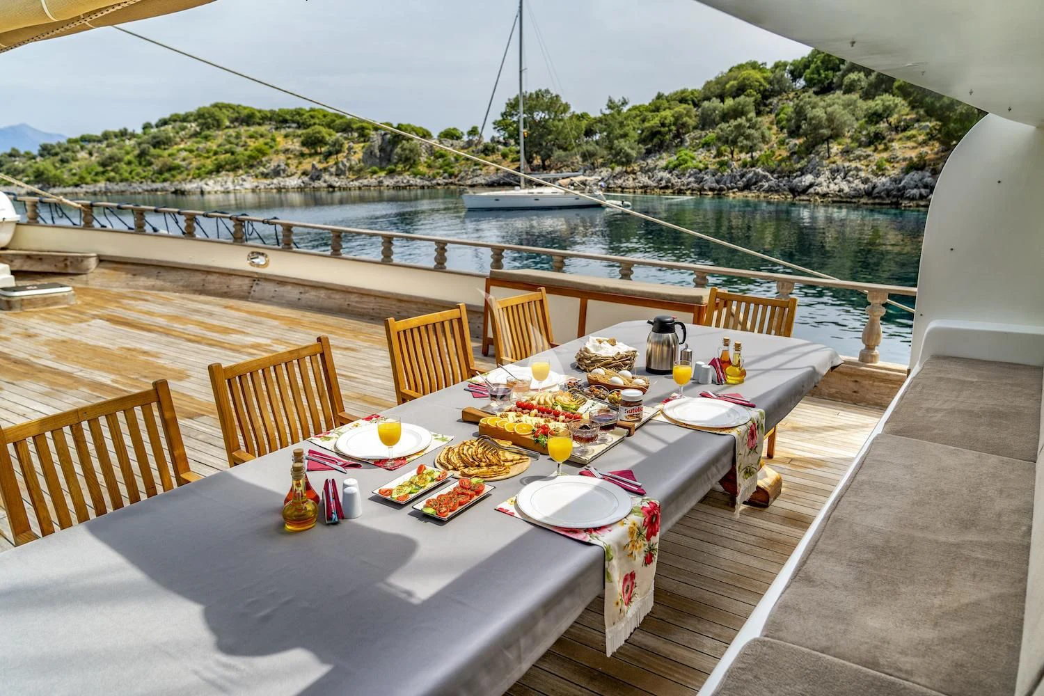 a table set with food on a balcony overlooking a body of water aboard TERSANE 8 Yacht for Sale