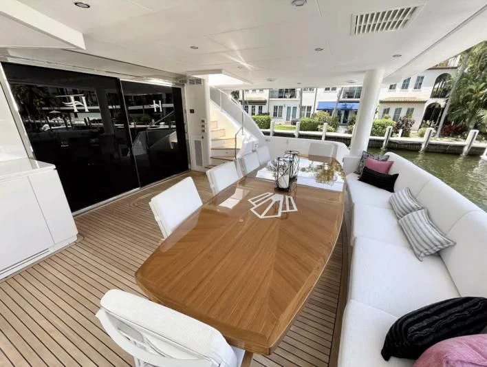 a large living room with a wood floor and white furniture aboard OBSESSION Yacht for Sale