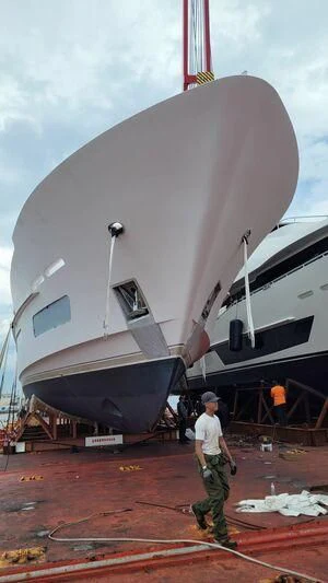 a man standing next to a large white boat aboard OBSESSION Yacht for Sale