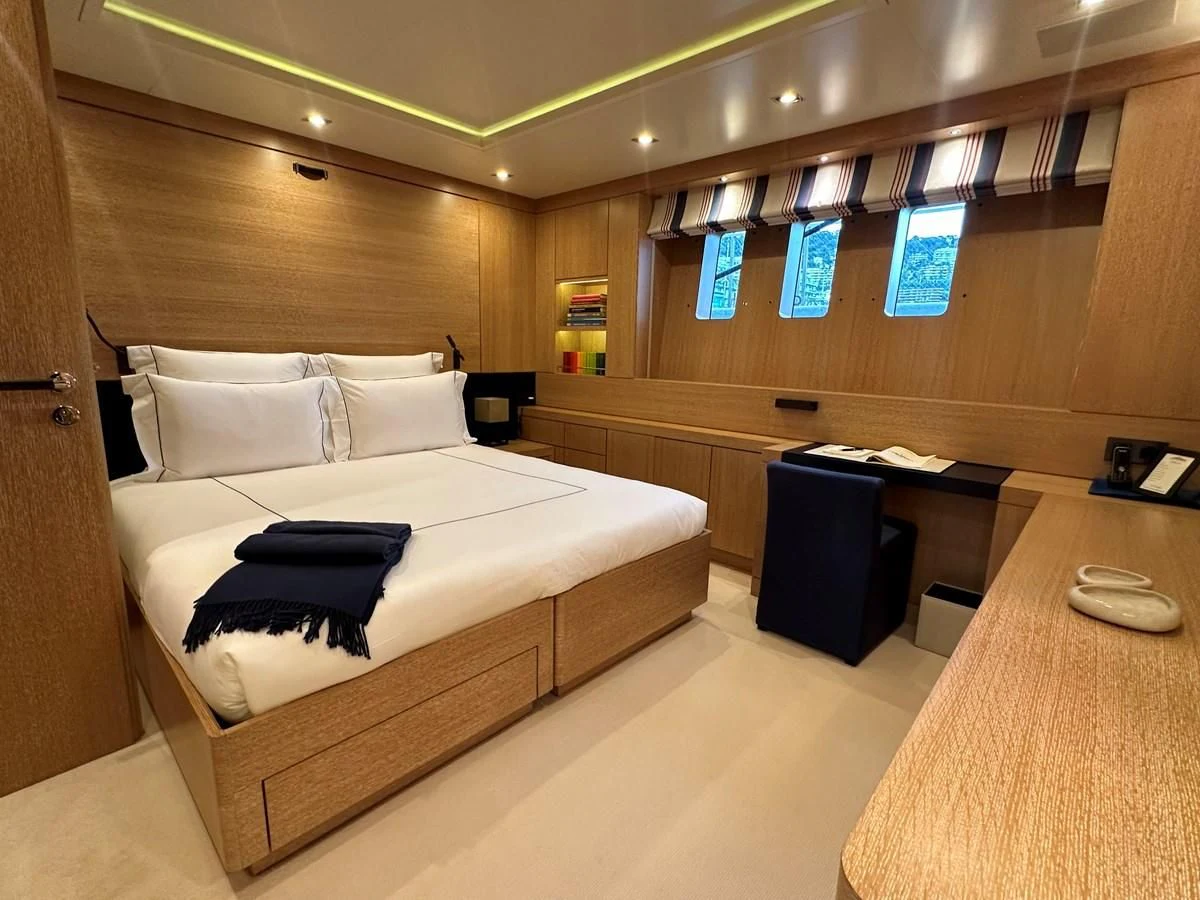 a room with a bed and desk aboard BELONGERS Yacht for Sale