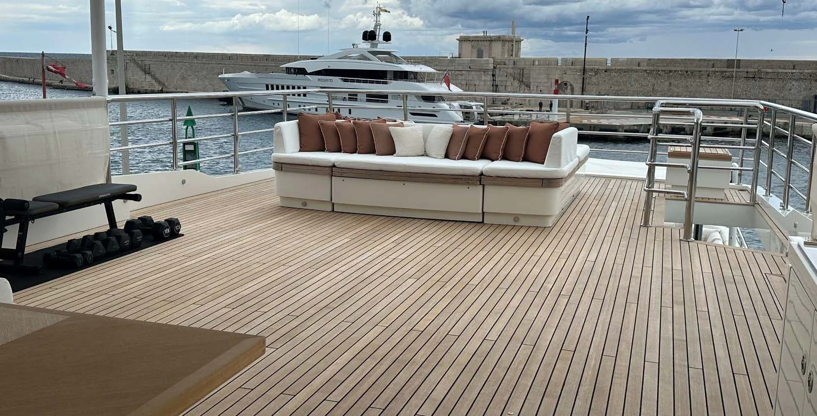 a couch on a deck overlooking a body of water aboard BELONGERS Yacht for Sale