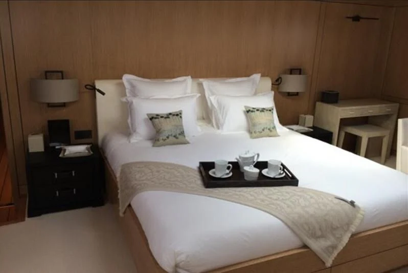 a bed with white sheets and pillows aboard BELONGERS Yacht for Sale