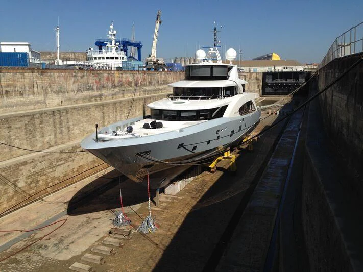 a boat on a river with HMS M33 in the background aboard BELONGERS Yacht for Sale
