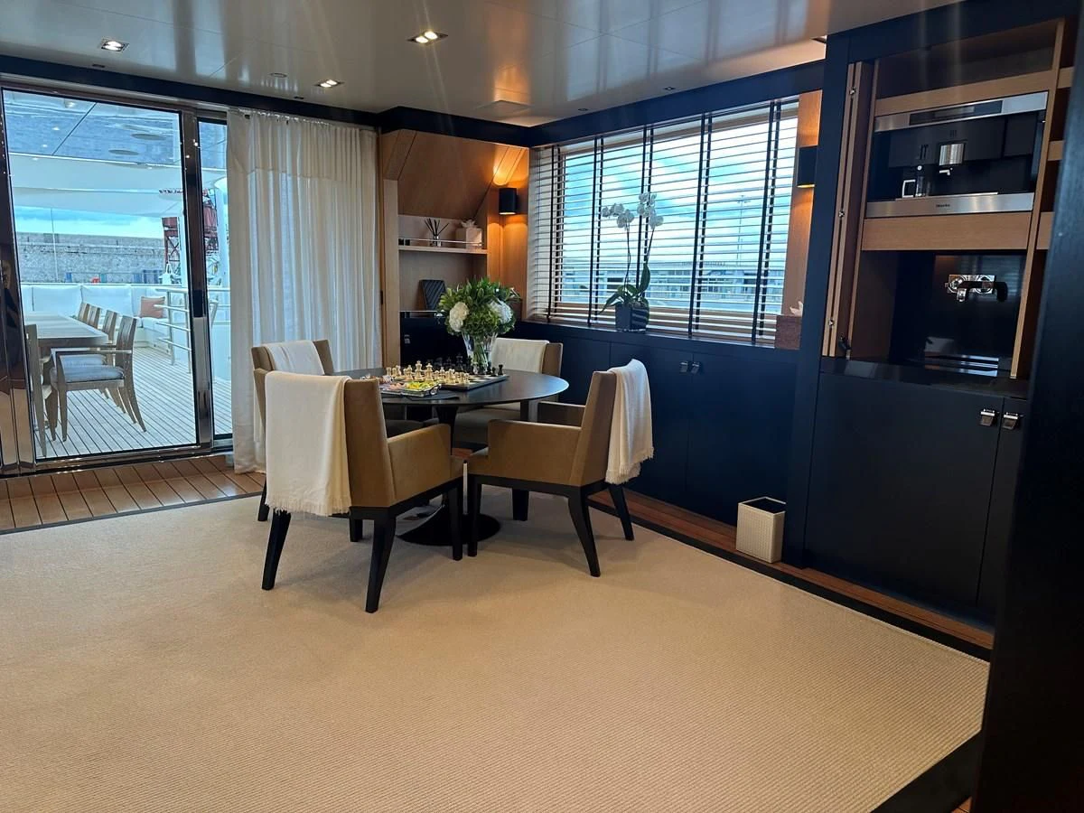 a room with a table chairs and a window aboard BELONGERS Yacht for Sale