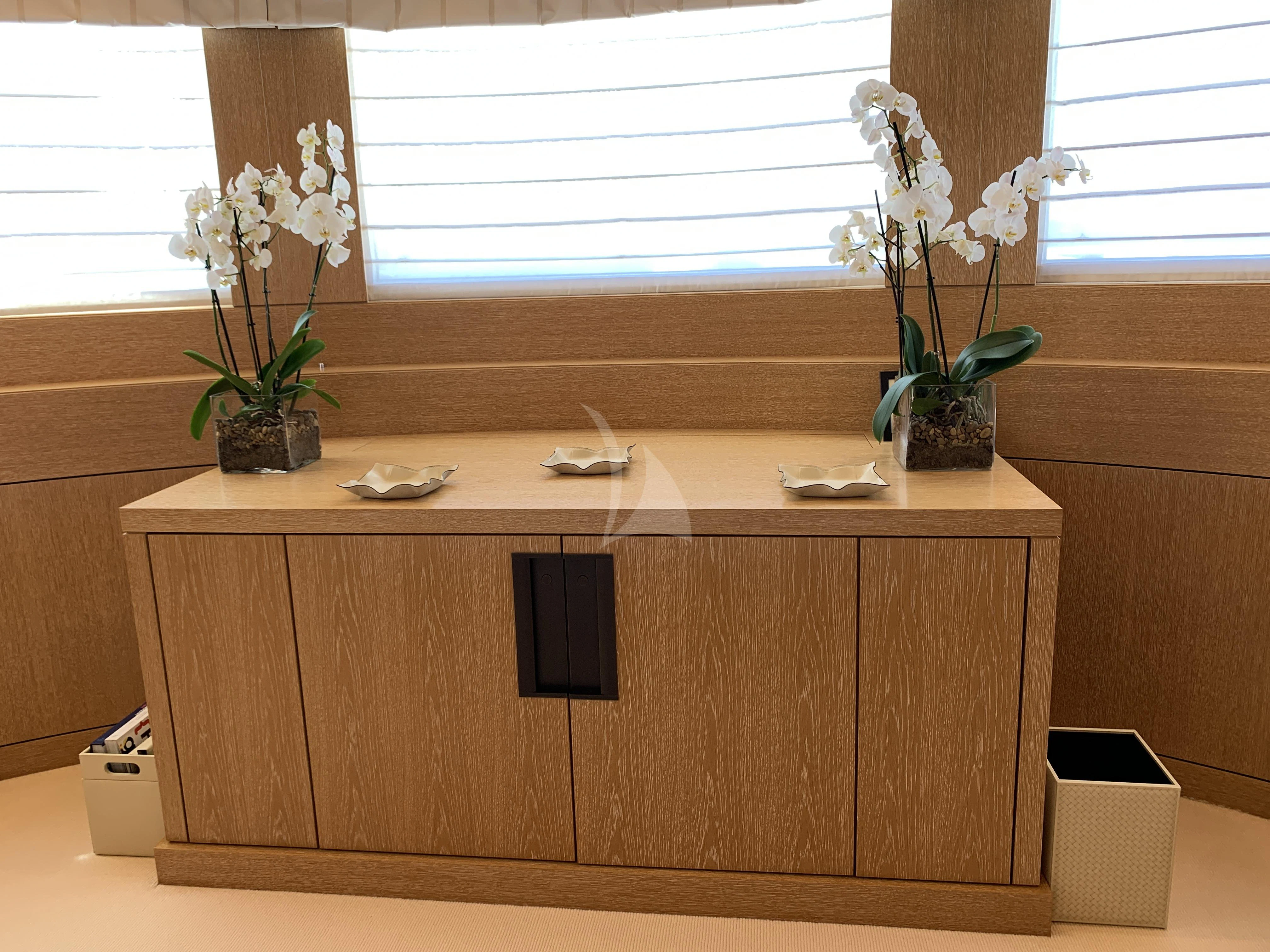 a desk with a computer and flowers aboard BELONGERS Yacht for Sale