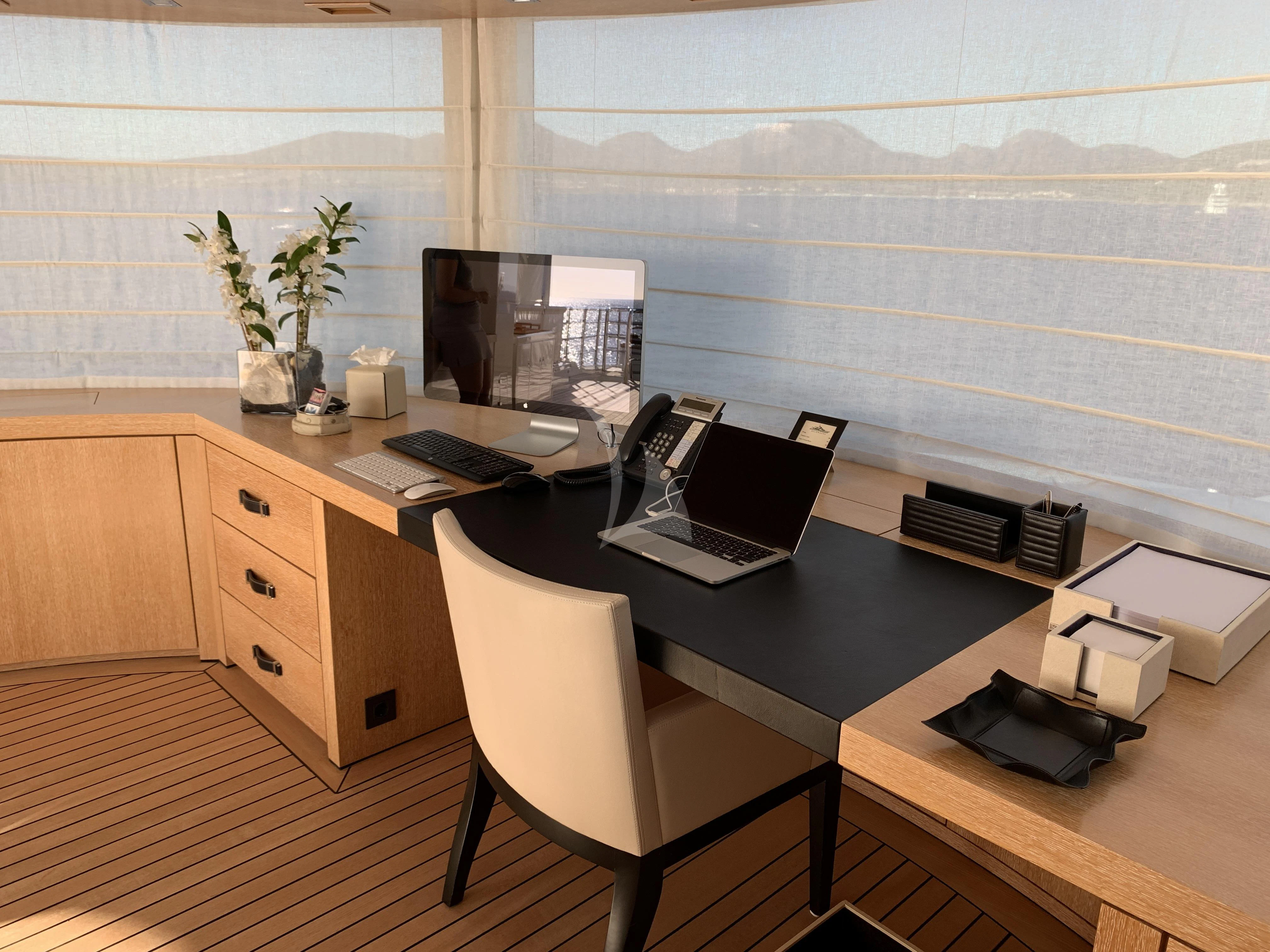 a desk with a computer and a printer on it aboard BELONGERS Yacht for Sale