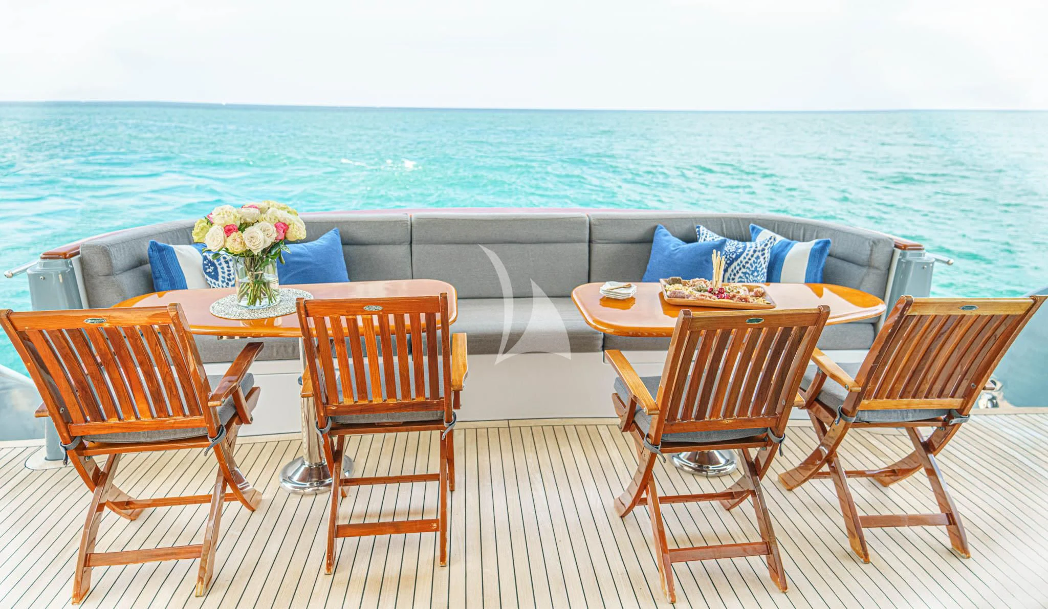 a table and chairs on a deck overlooking a beach aboard LADY VICTORY Yacht for Sale