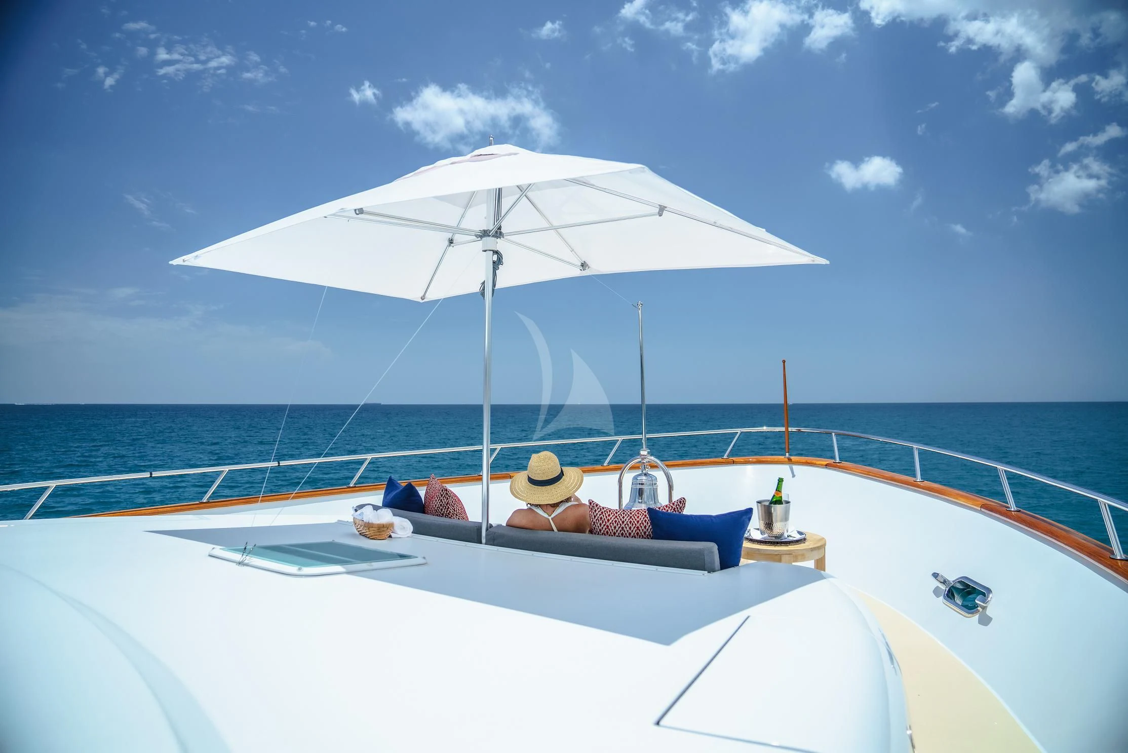 a person lying on a lounge chair under an umbrella on a boat aboard LADY VICTORY Yacht for Sale
