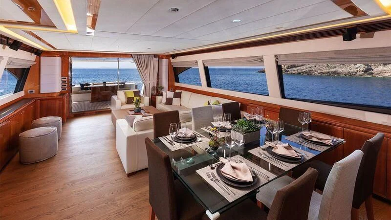 a dining room with a large window aboard ANNOUKA TWINS Yacht for Sale