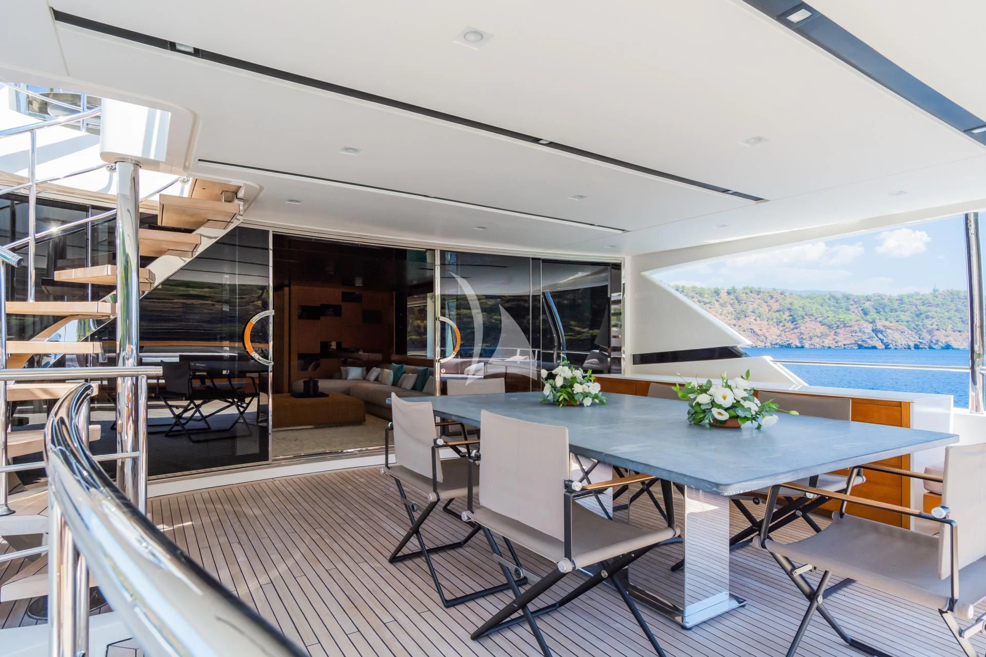 a large open space with a table and chairs and a view of the ocean aboard TAKARA ONE Yacht for Charter